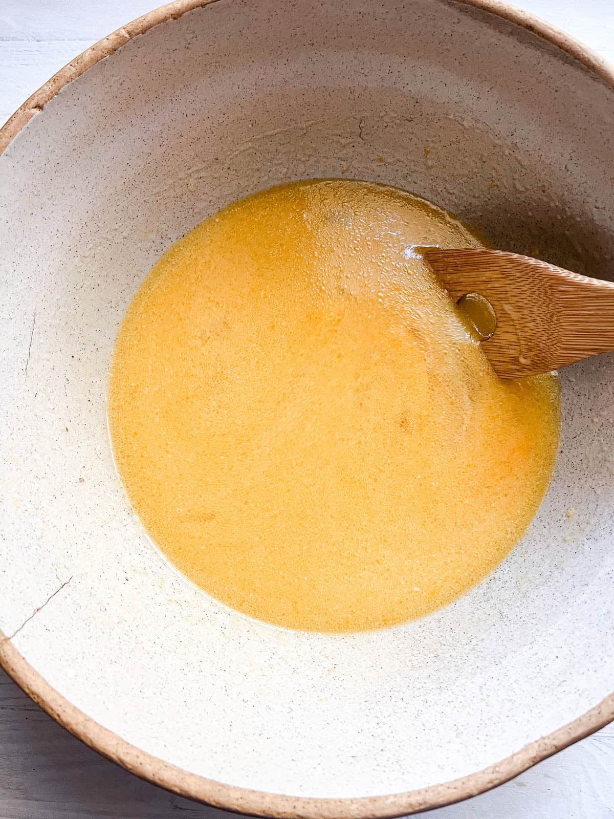 Stirring wet ingredients in a large mixing bowl. 