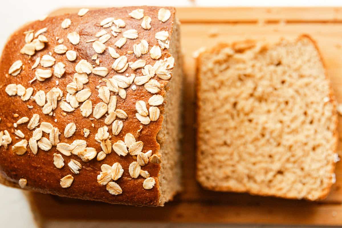 Looking down on a loaf of seeded whole grain bread that is partially sliced.