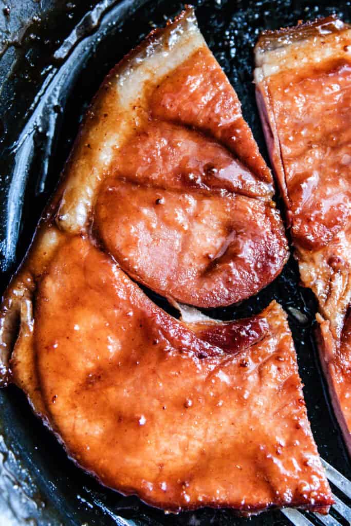 Ham steak in a cast iron skillet.
