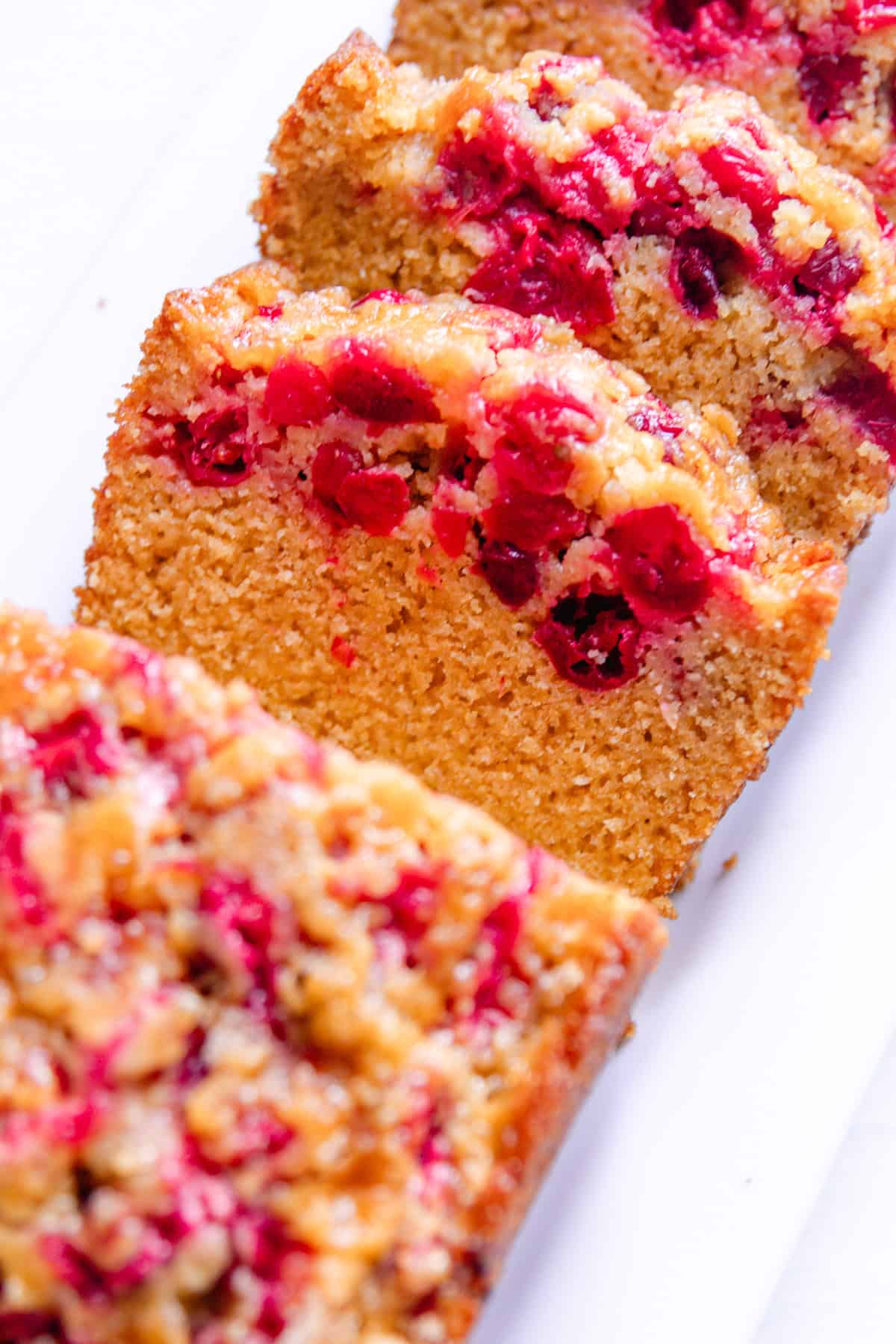 Slices of whole grain cranberry bread layered on a white plate.
