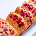 Slices of whole grain cranberry bread layered on a white plate.