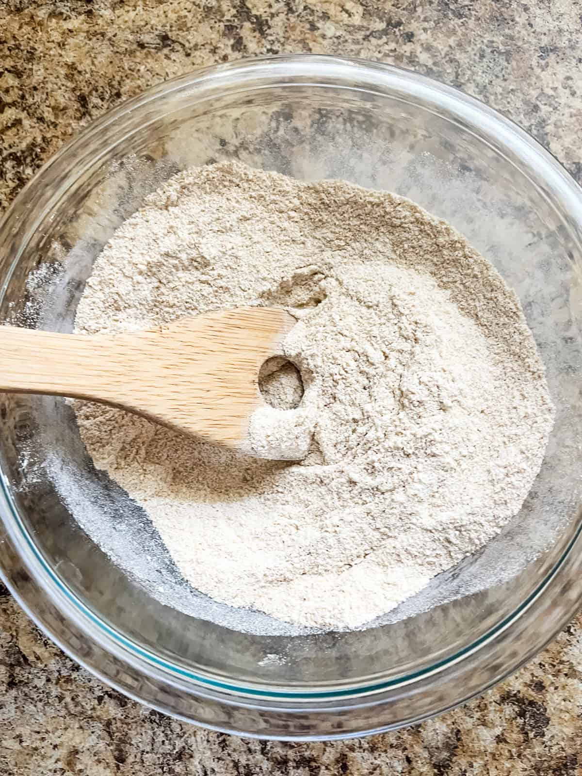 Stirring dry ingredients in a glass bowl. 