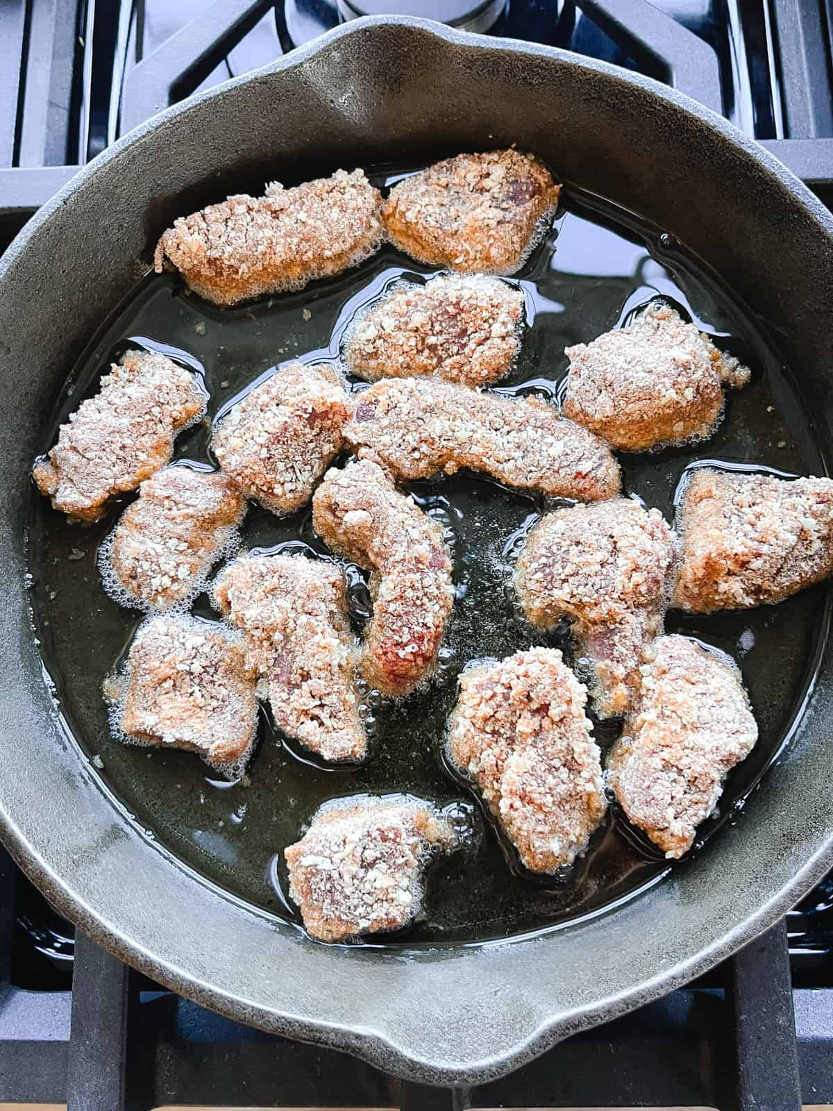 Frying venison nuggets in a cast iron skillet with lard.