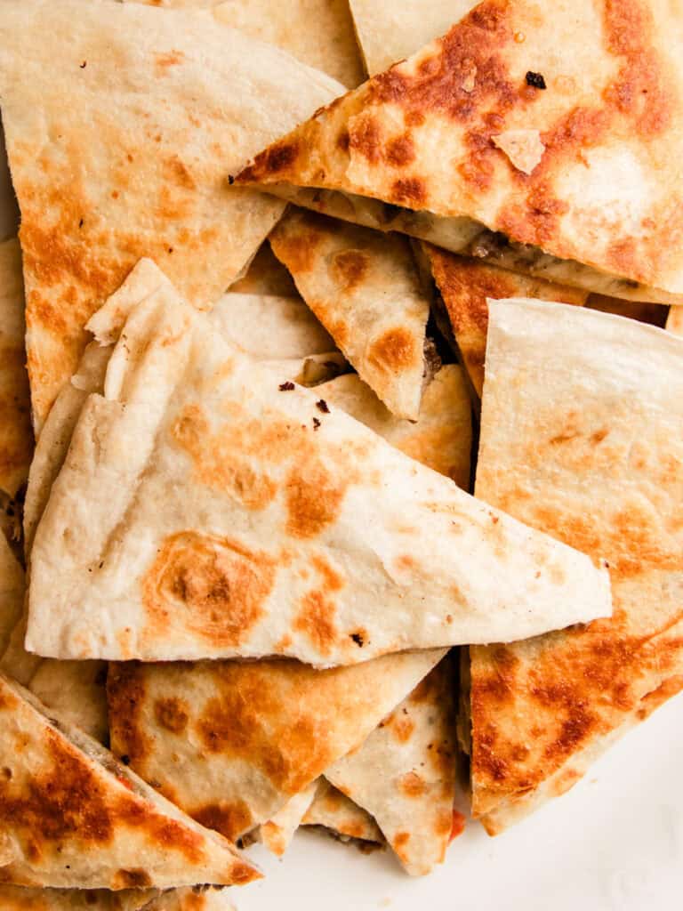 Looking down on a plate of venison quesadillas cut into triangles.
