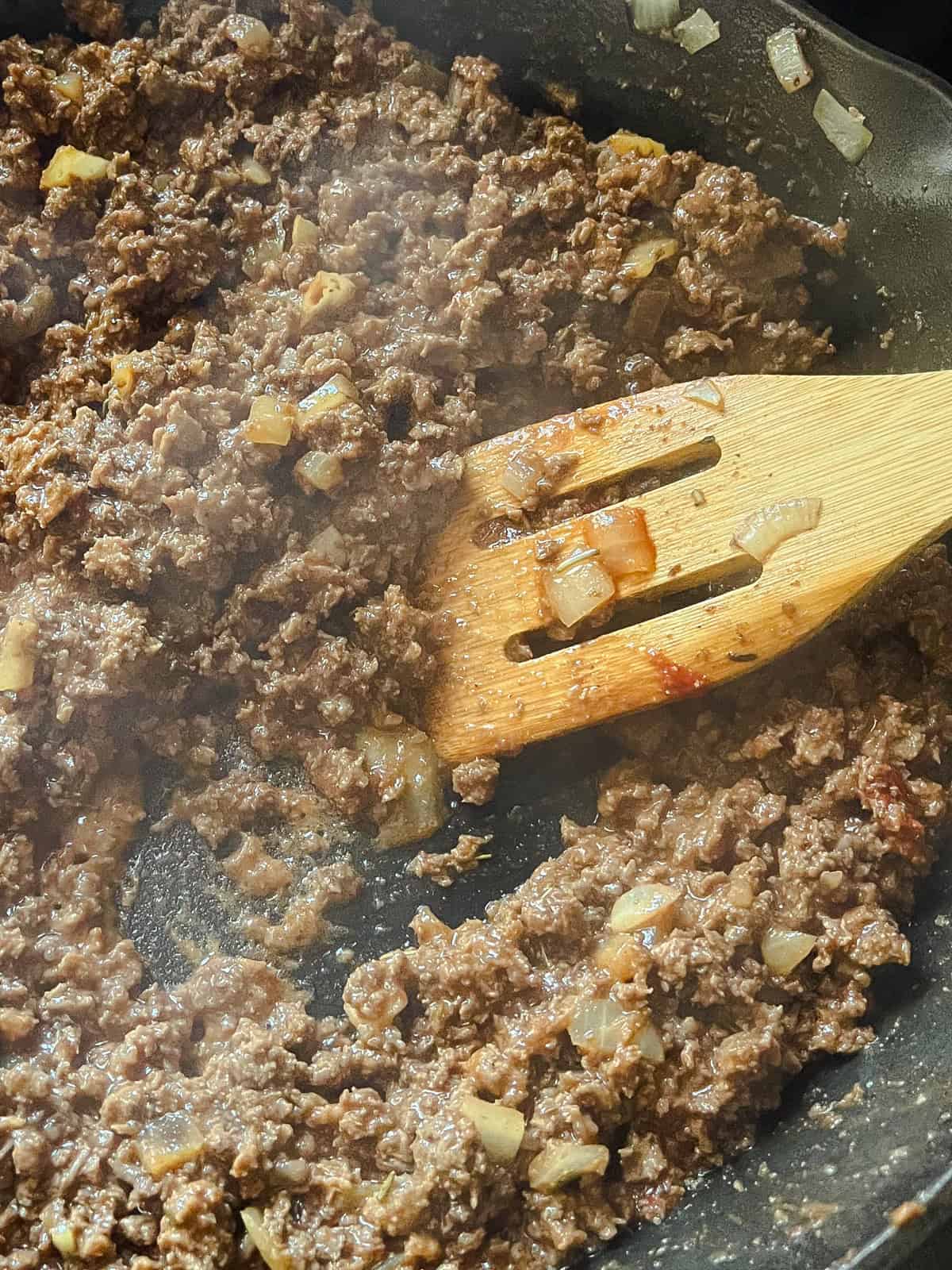 Browned venison in a cast iron skillet.