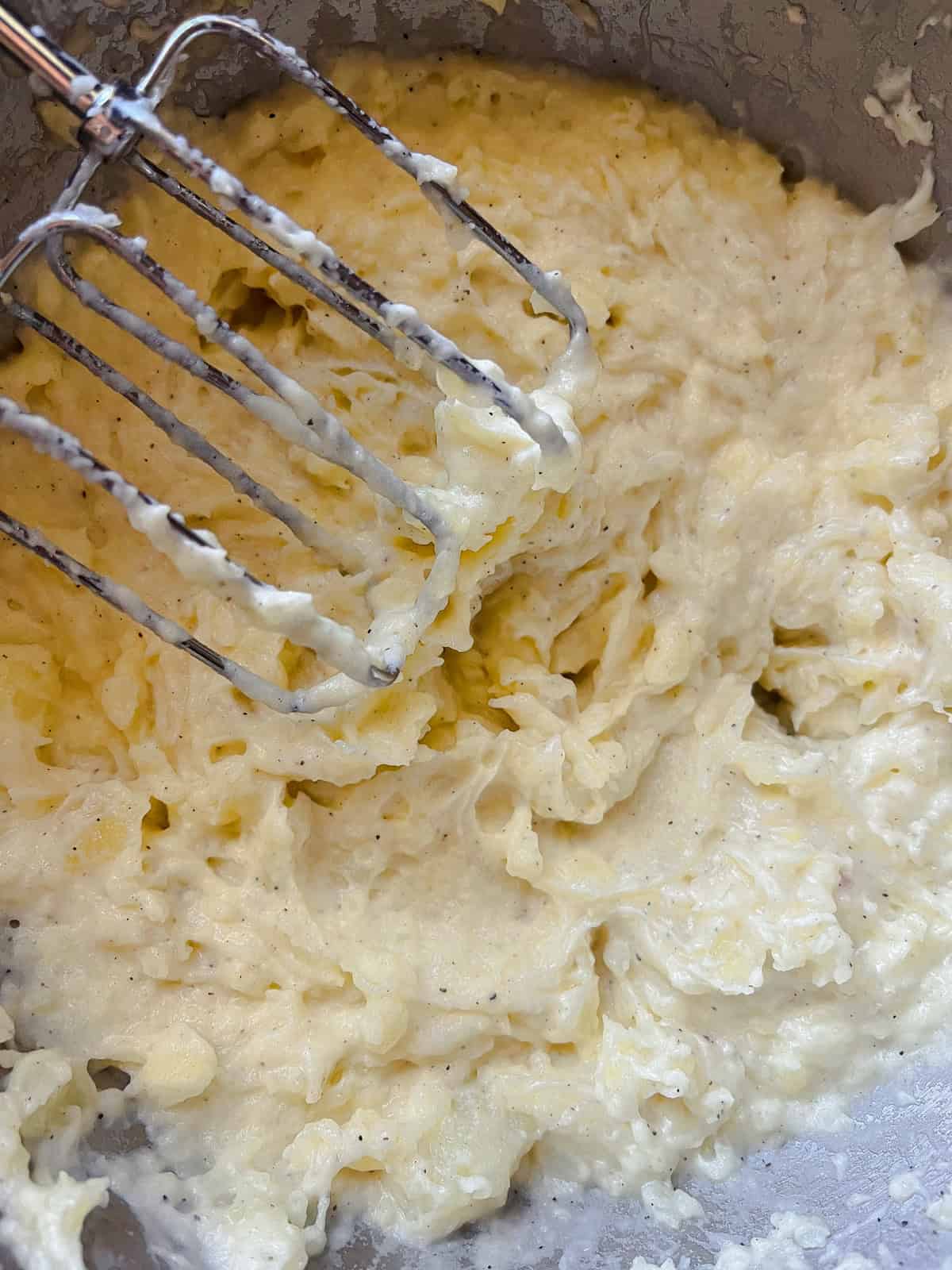 Whipping mashed potatoes with a hand mixer.