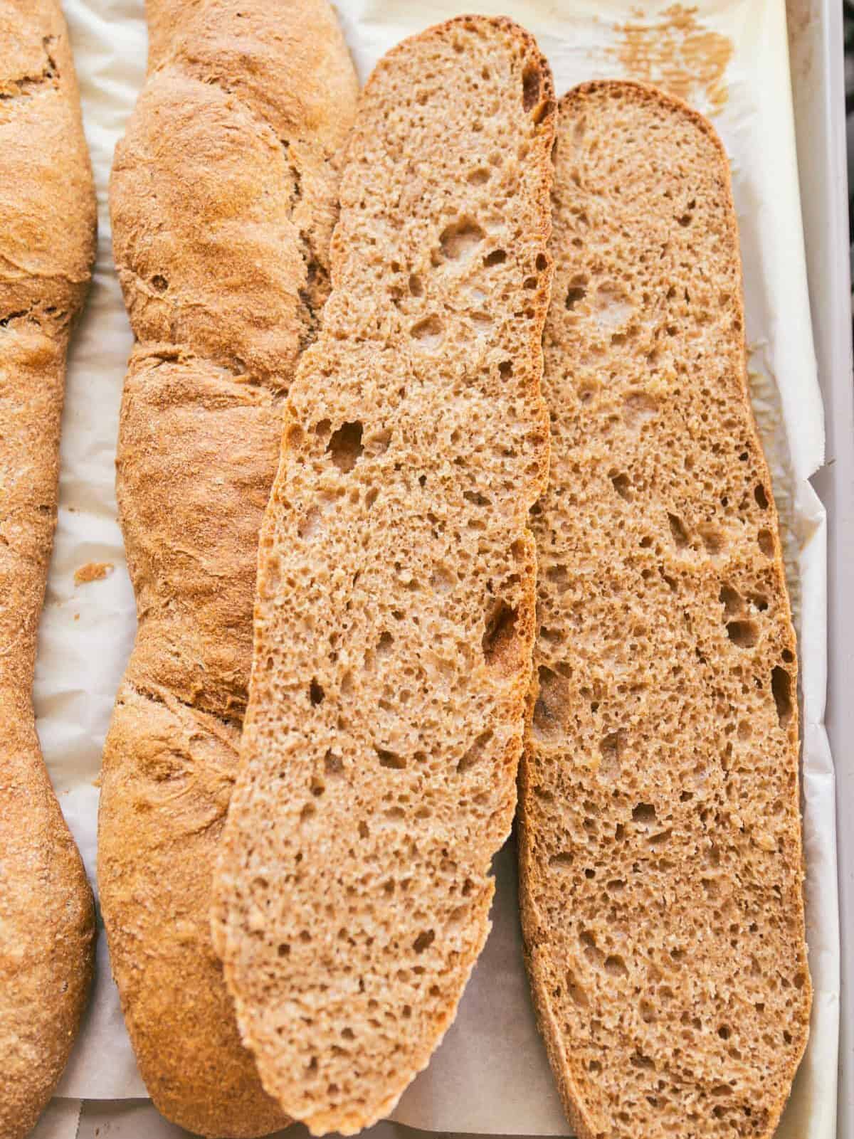 Baguettes with fresh milled flour stacked on a baking sheet.