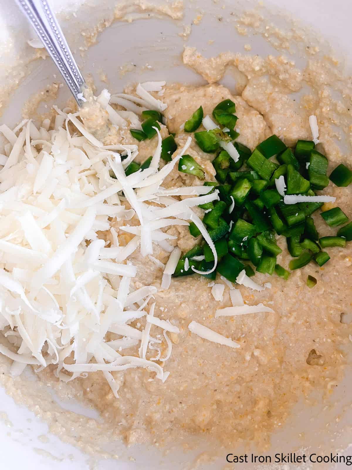 Adding jalapenos and cheese to a bowl of fresh milled cornbread batter.