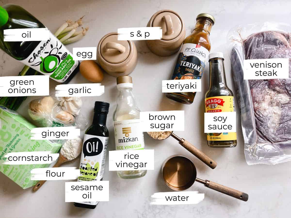 Garlic ginger venison ingredients labeled on a white counter.