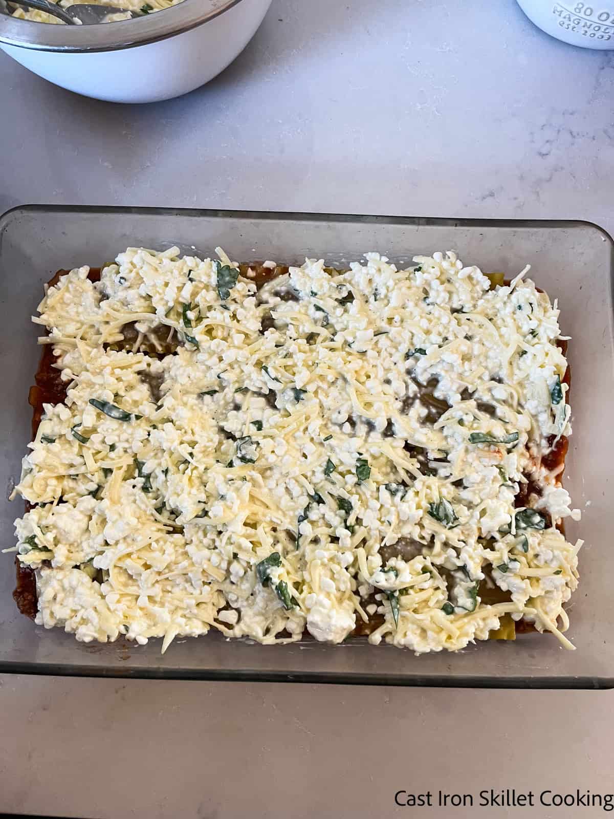 Spreading cheese mixture in a layer in a venison lasagna.