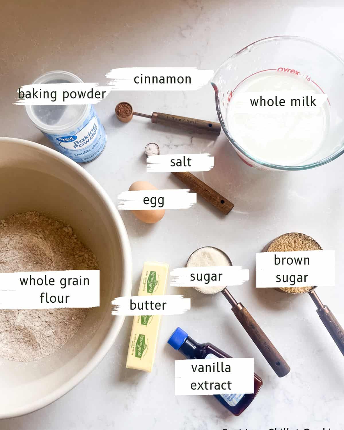 Whole grain cinnamon sugar muffins ingredients labeled on a white table.