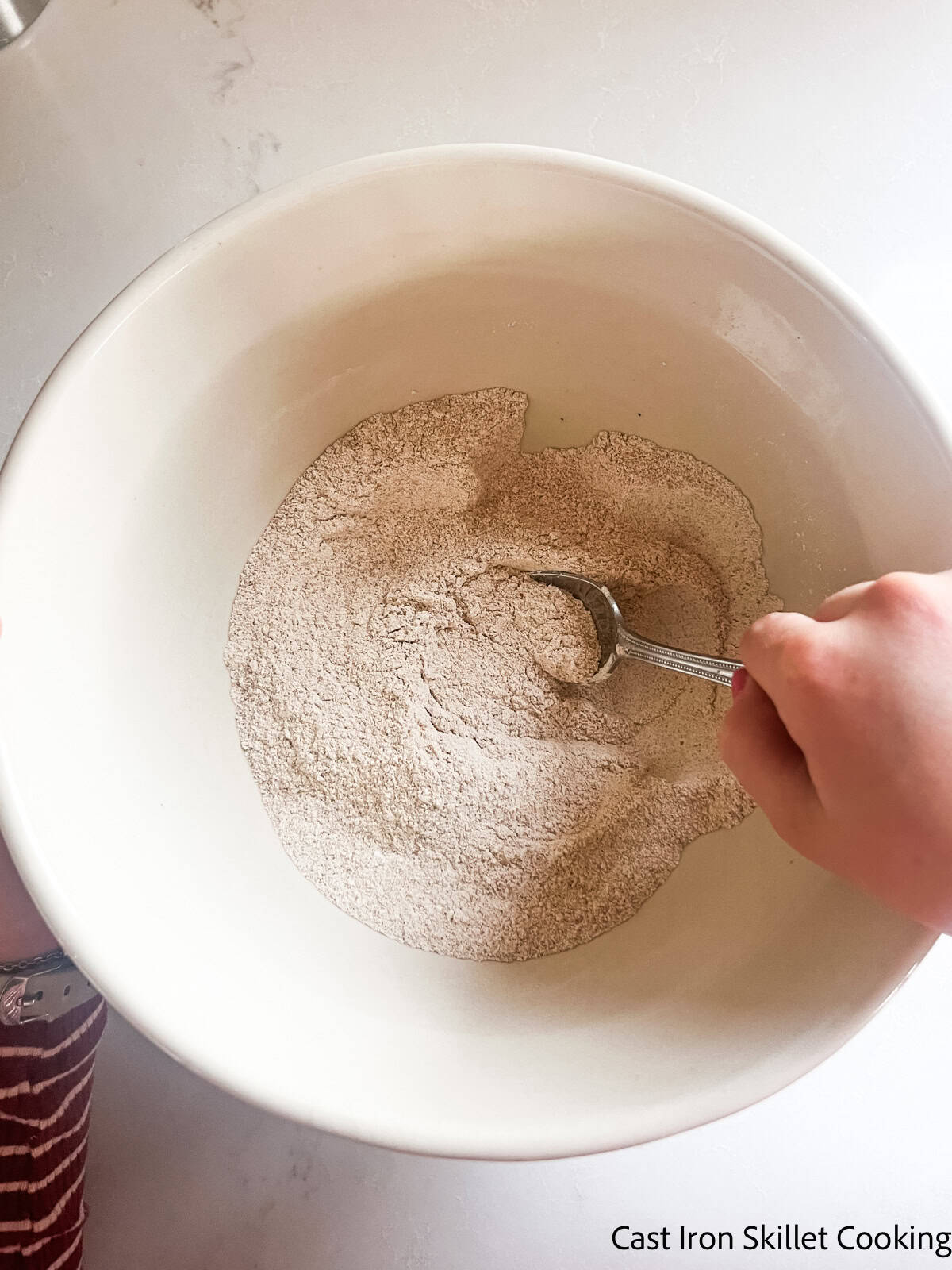 Stirring dry ingredients in a bowl.