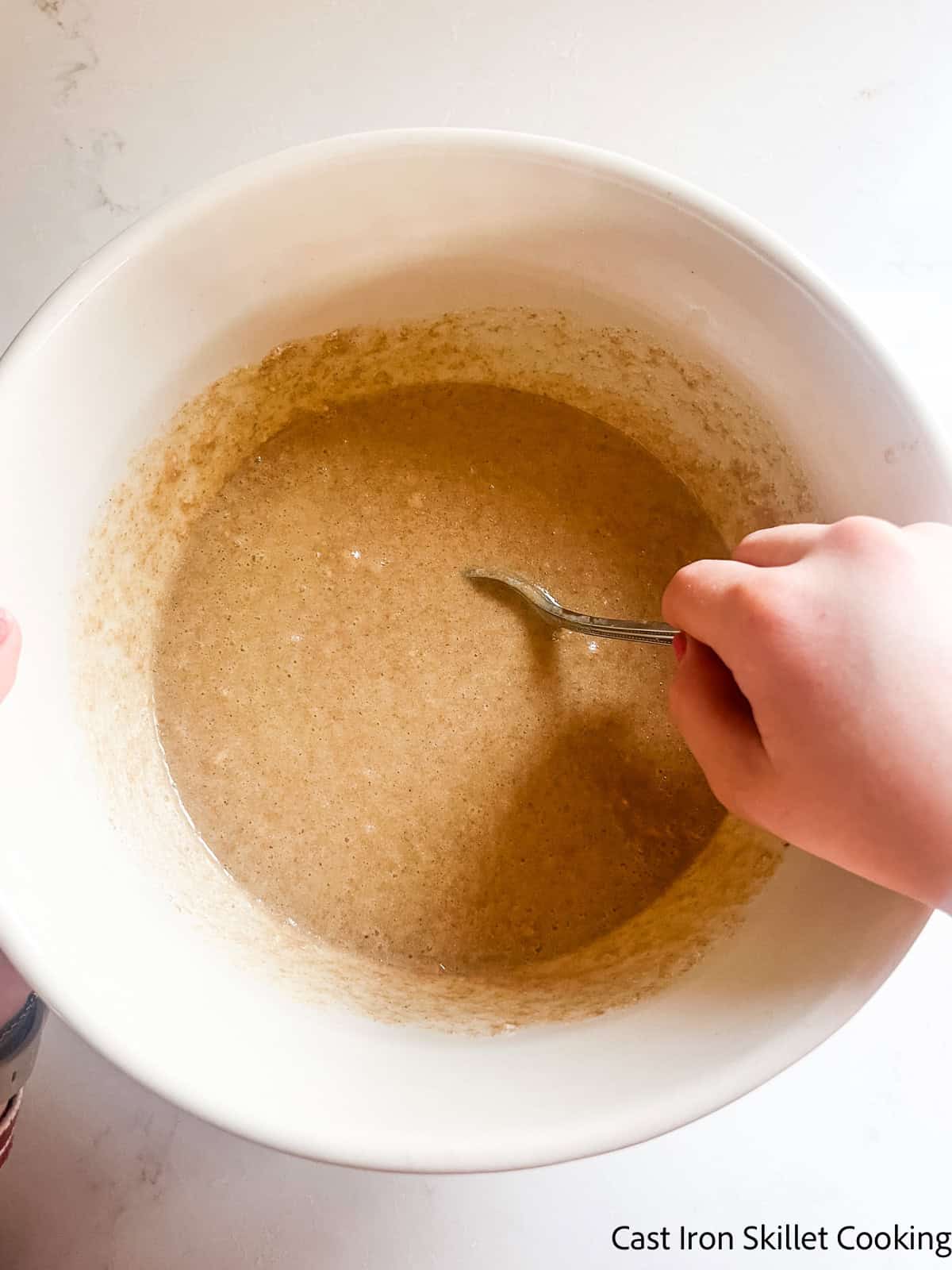 Stirring wet ingredients in a bowl.