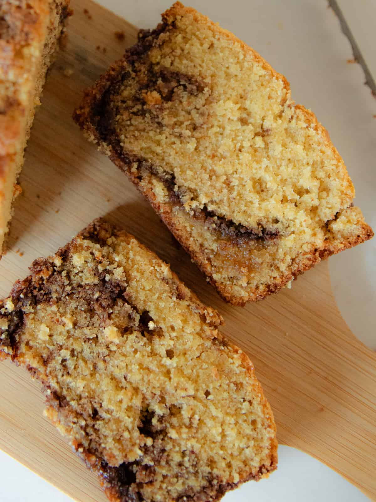 Two slices of fresh milled cinnamon swirl bread on a wooden cutting board.