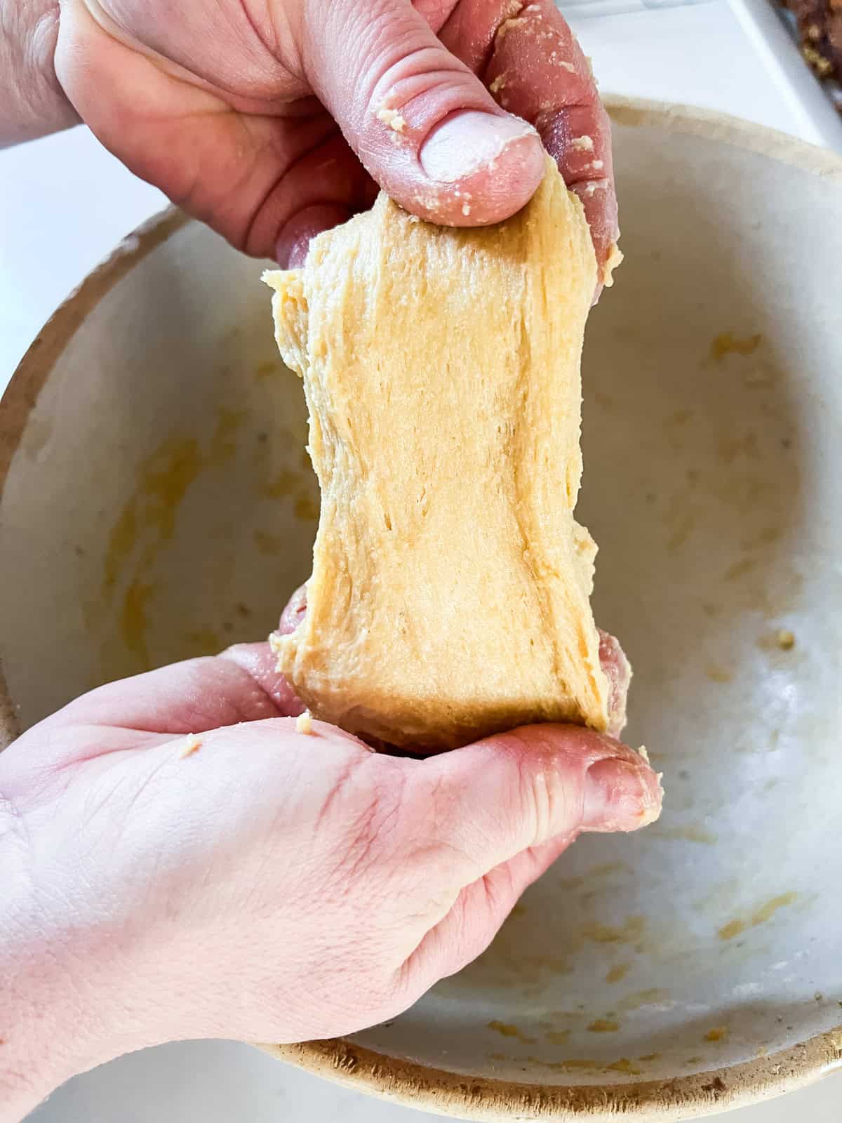 Stretching a piece of Hawaiian roll dough.