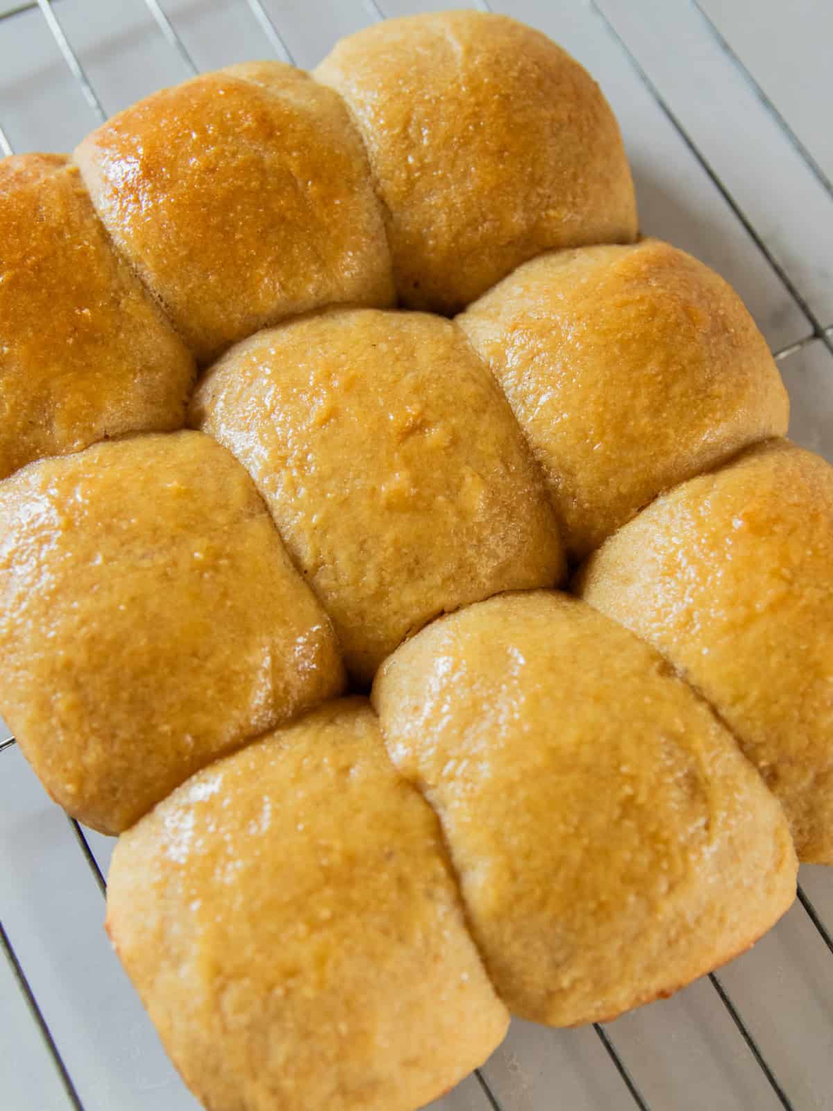 Fresh milled flour Hawaiian rolls cooling on a baking rack.