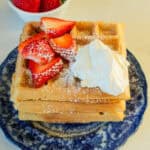 A stack of fresh milled waffles with berries on top.
