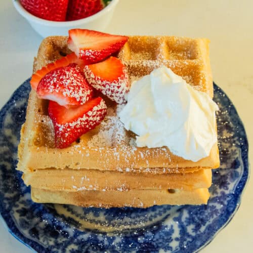 A stack of fresh milled waffles with berries on top.