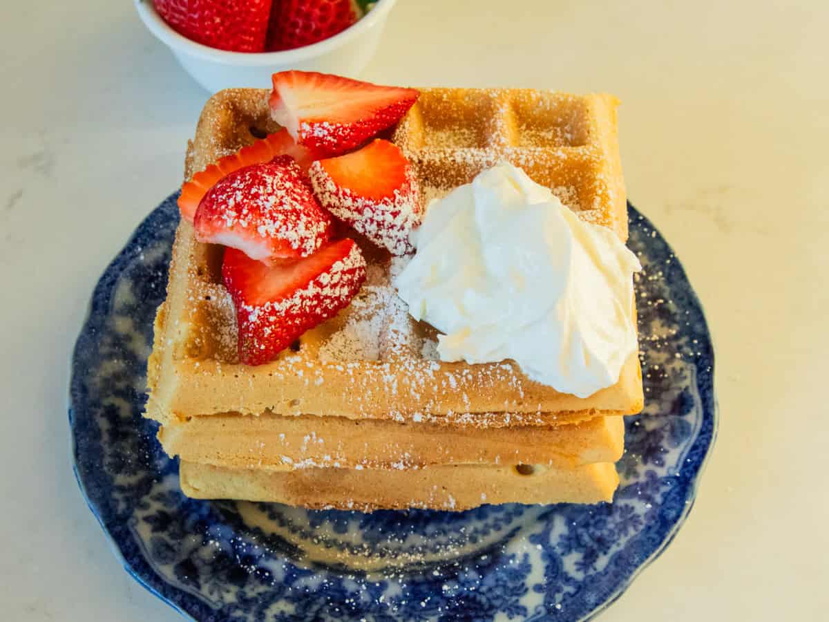 A stack of fresh milled waffles with berries on top. 