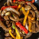 Venison fajitas in a cast iron skillet.