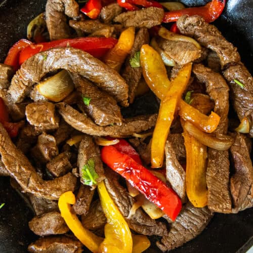 Venison fajitas in a cast iron skillet.