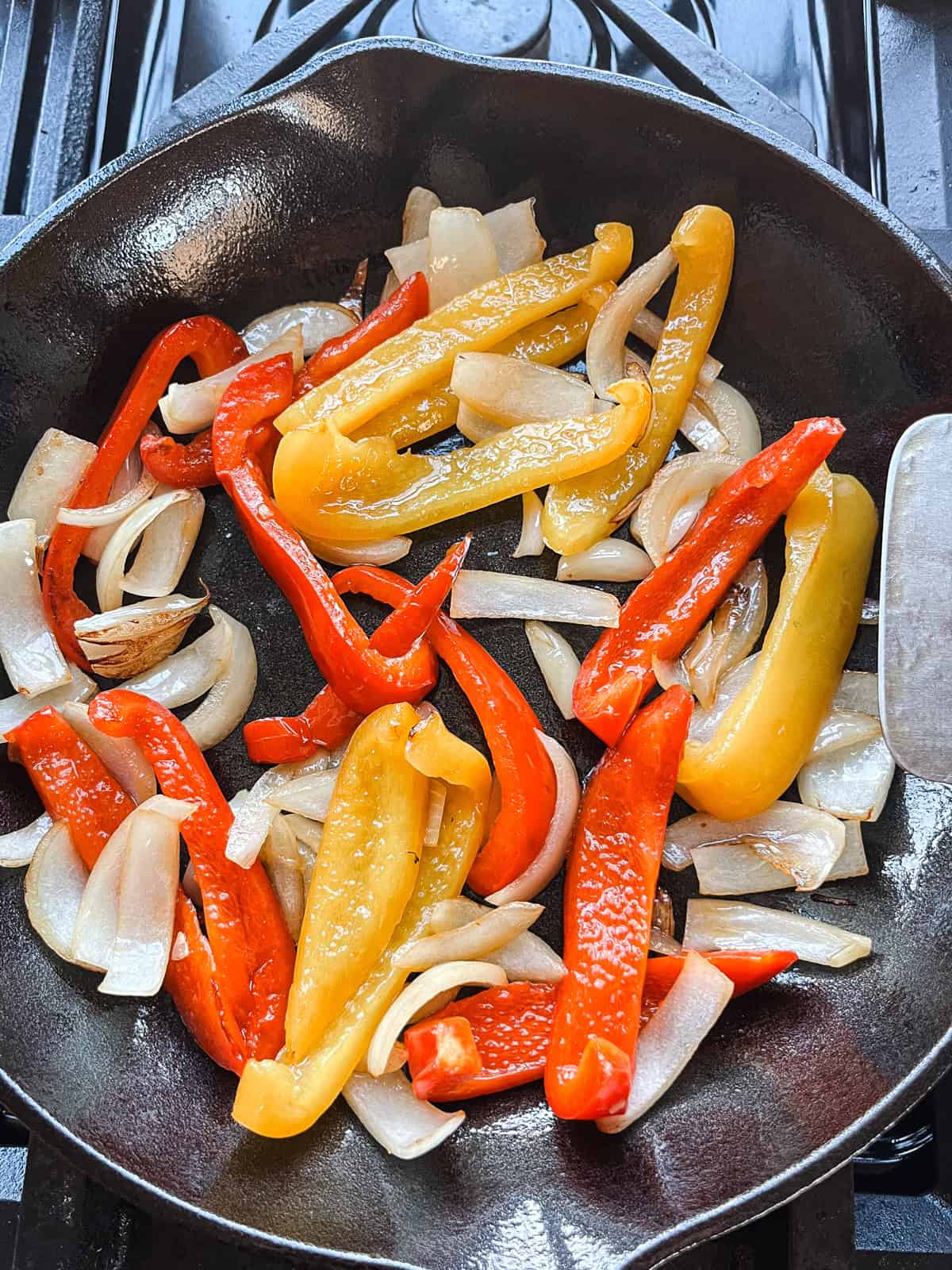 Sauteing peppers and onions in a cast iron skillet.