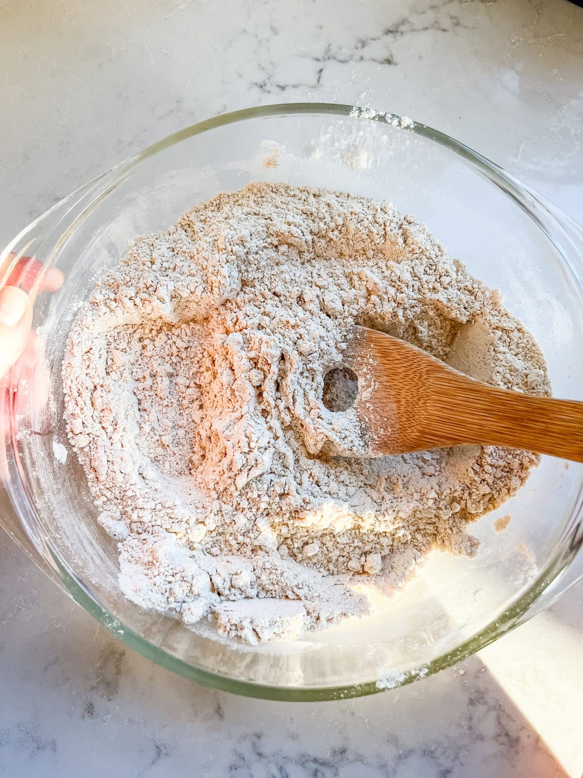 Stirring dry ingredients in a glass mixing bowl.