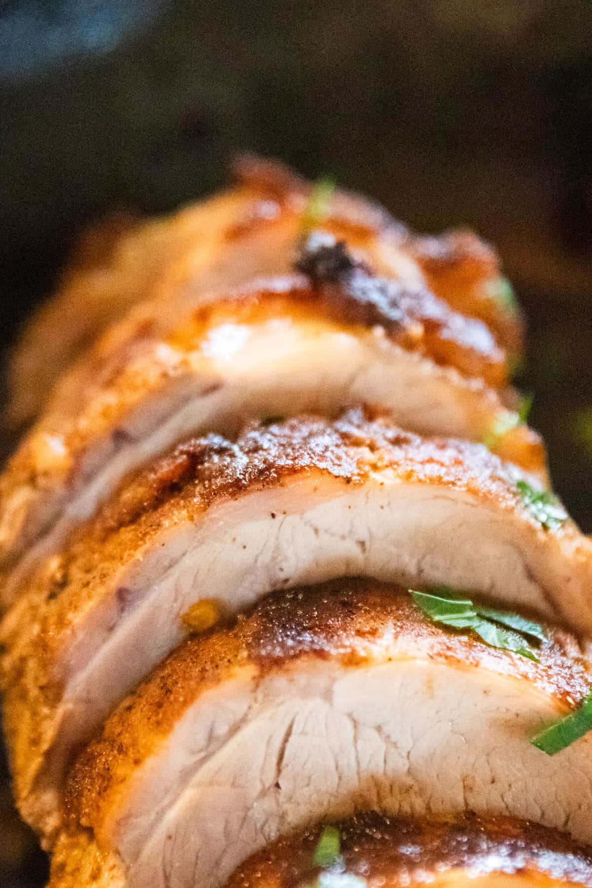 Sliced baked pork tenderloin in a cast iron skillet.