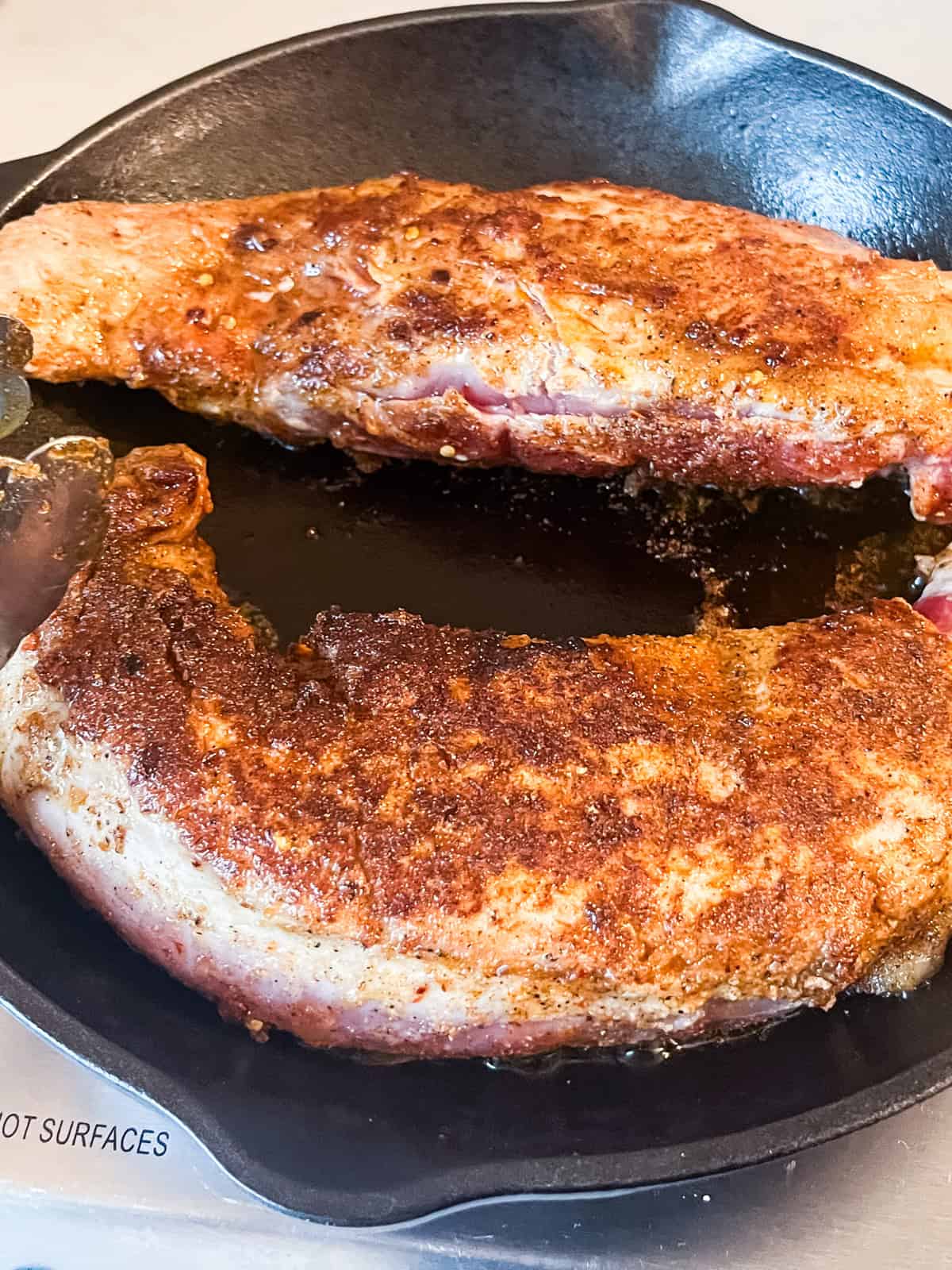 Searing a pork tenderloin in a cast iron skillet.
