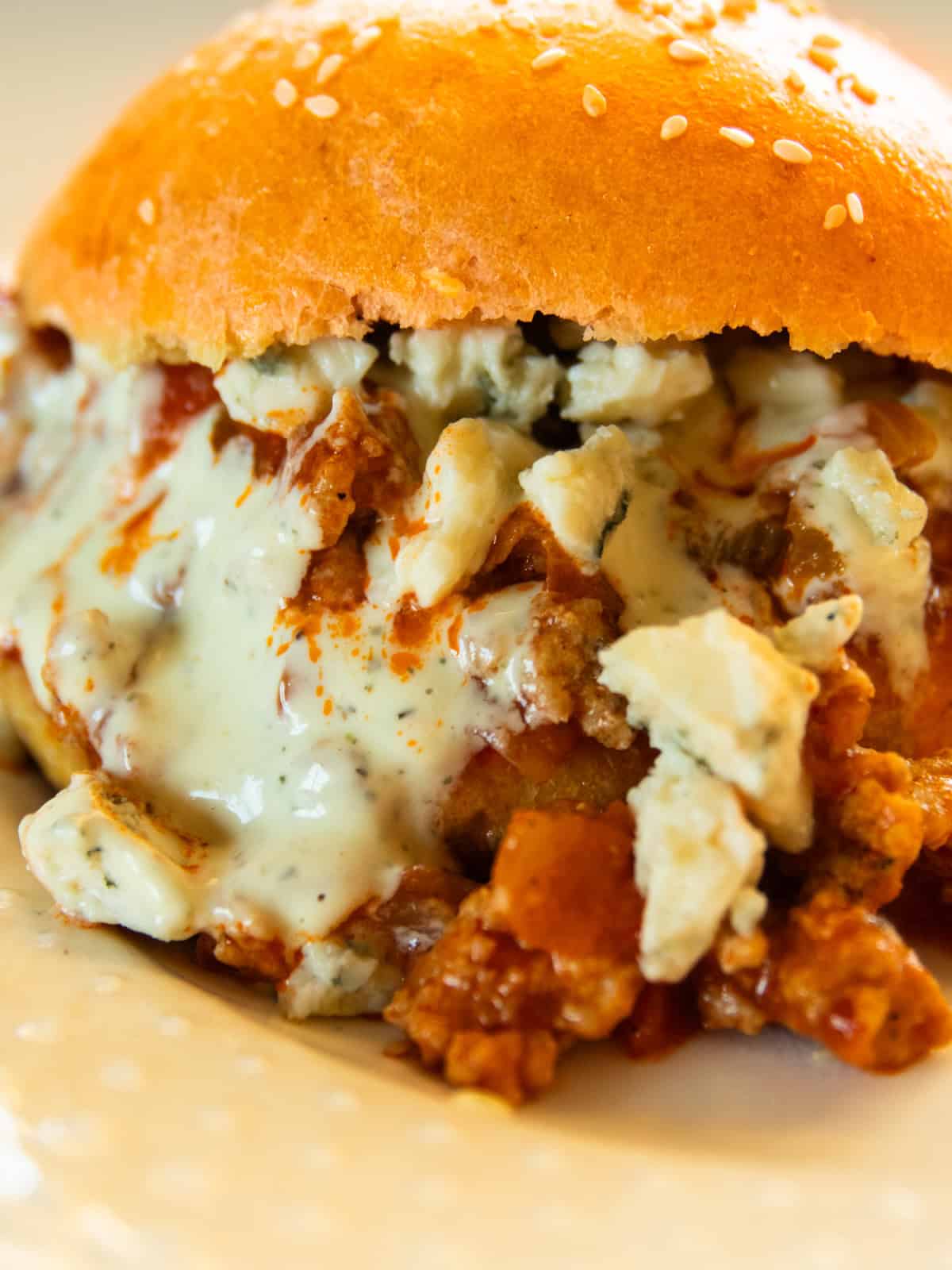 A buffalo chicken sloppy joe with ranch on a white plate.