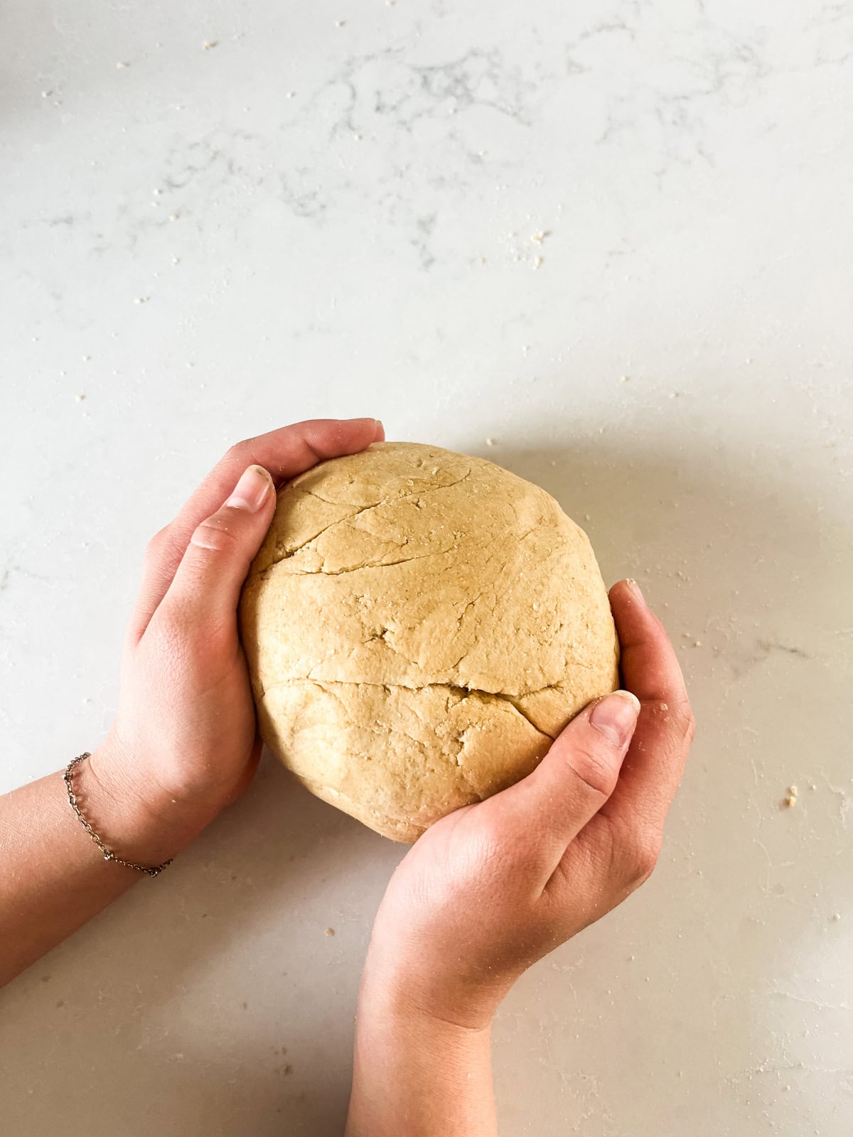 Shaping pretzel dough into a ball by hand.