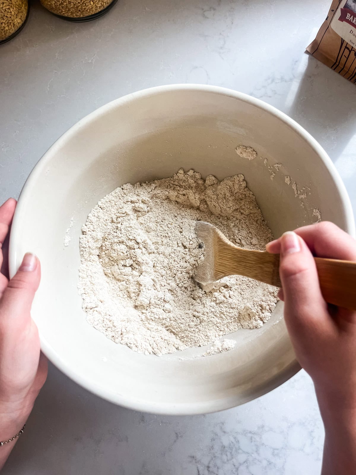Mixing dry ingredients in a mixing bowl with a wooden spoon.