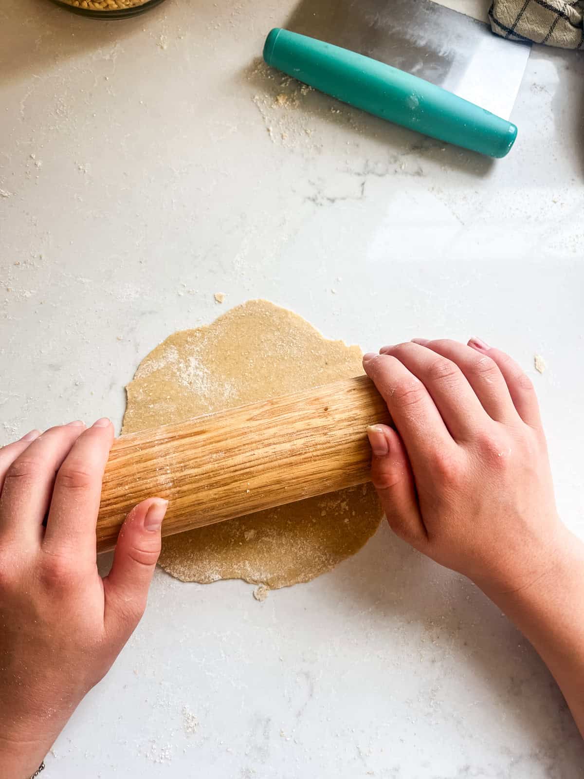 Rolling a ball of tortilla dough flat into a tortilla shape.