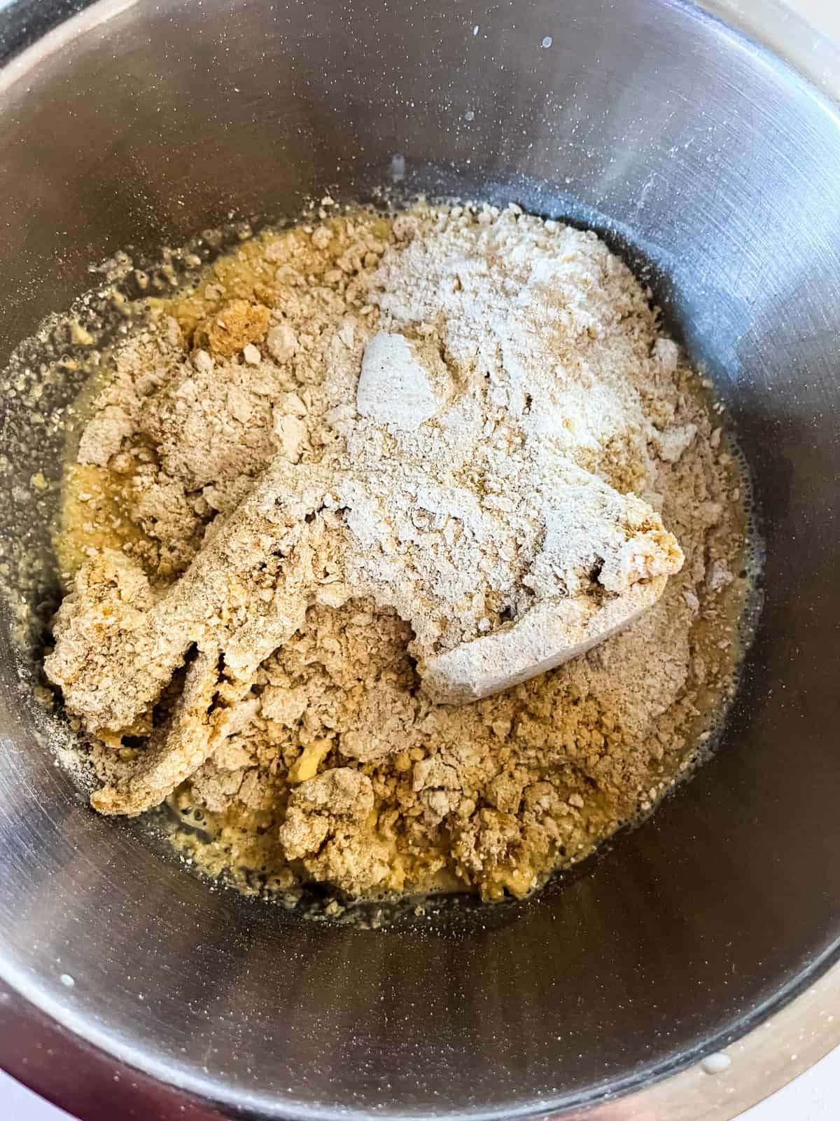 Donut dough roughly mixed in a metal bowl.