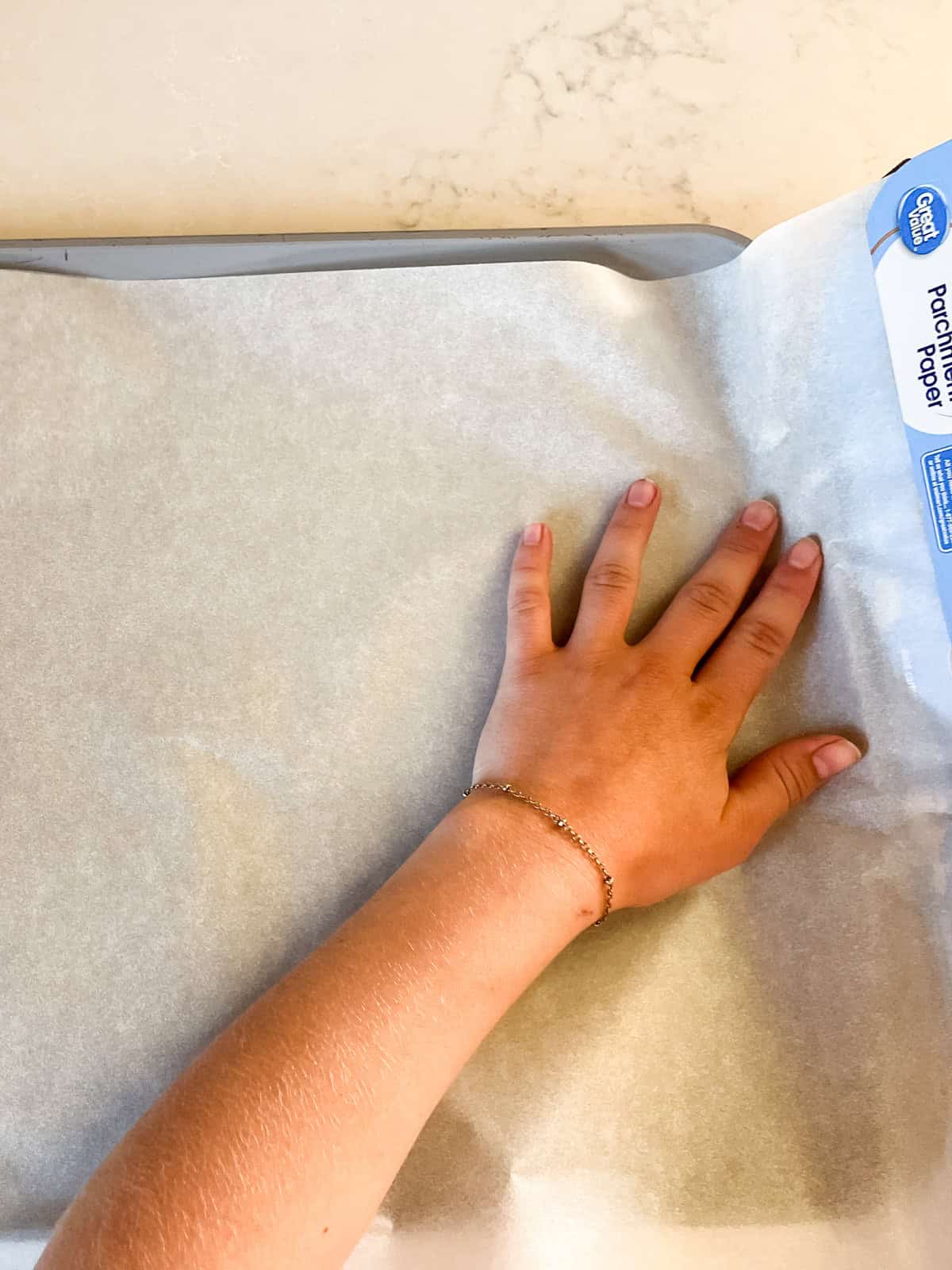 Lining a baking sheet with parchment paper.