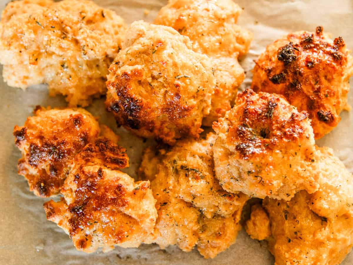 Cheddar biscuits with freshly milled flour stacked on a plate.