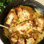 Creamy garlic chicken in a cast iron skillet with fresh parsley.