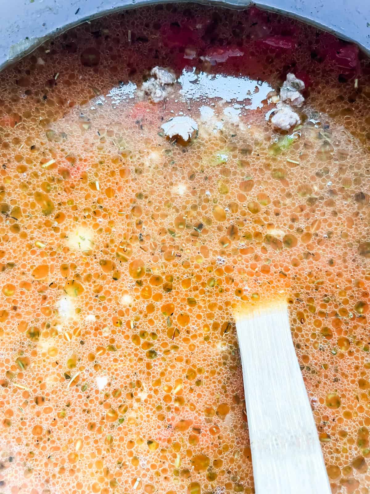 Dutch oven pizza soup simmering in a pot.