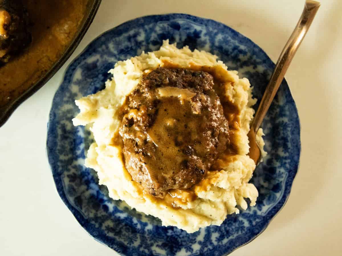 Venison salisbury steak on a bed of mashed potatoes.