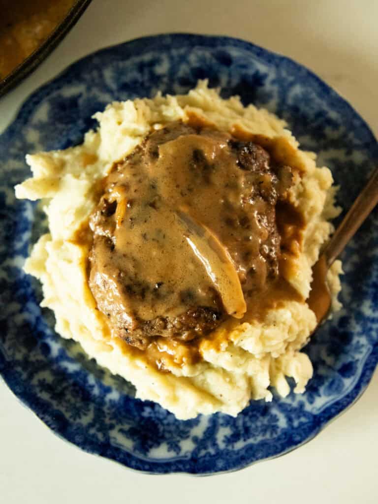 Venison salisbury steak on a bed of mashed potatoes.