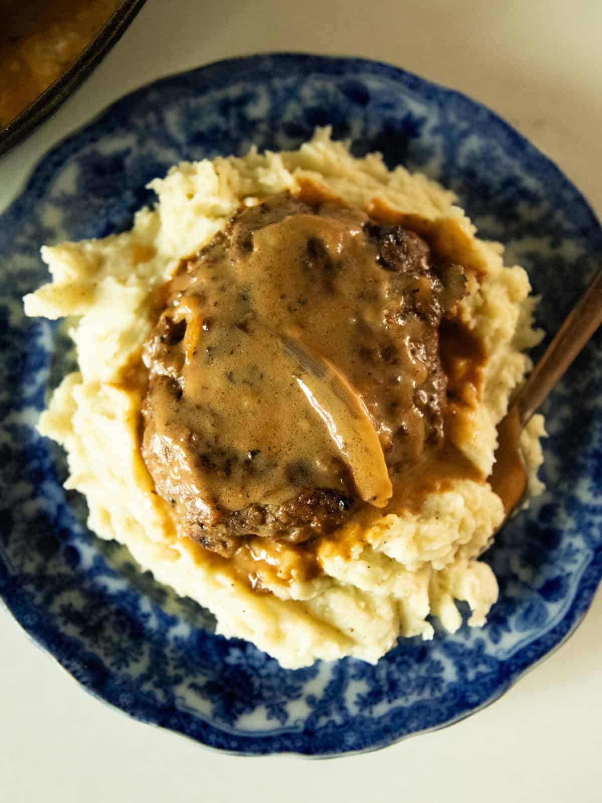 Venison salisbury steak on a bed of mashed potatoes.