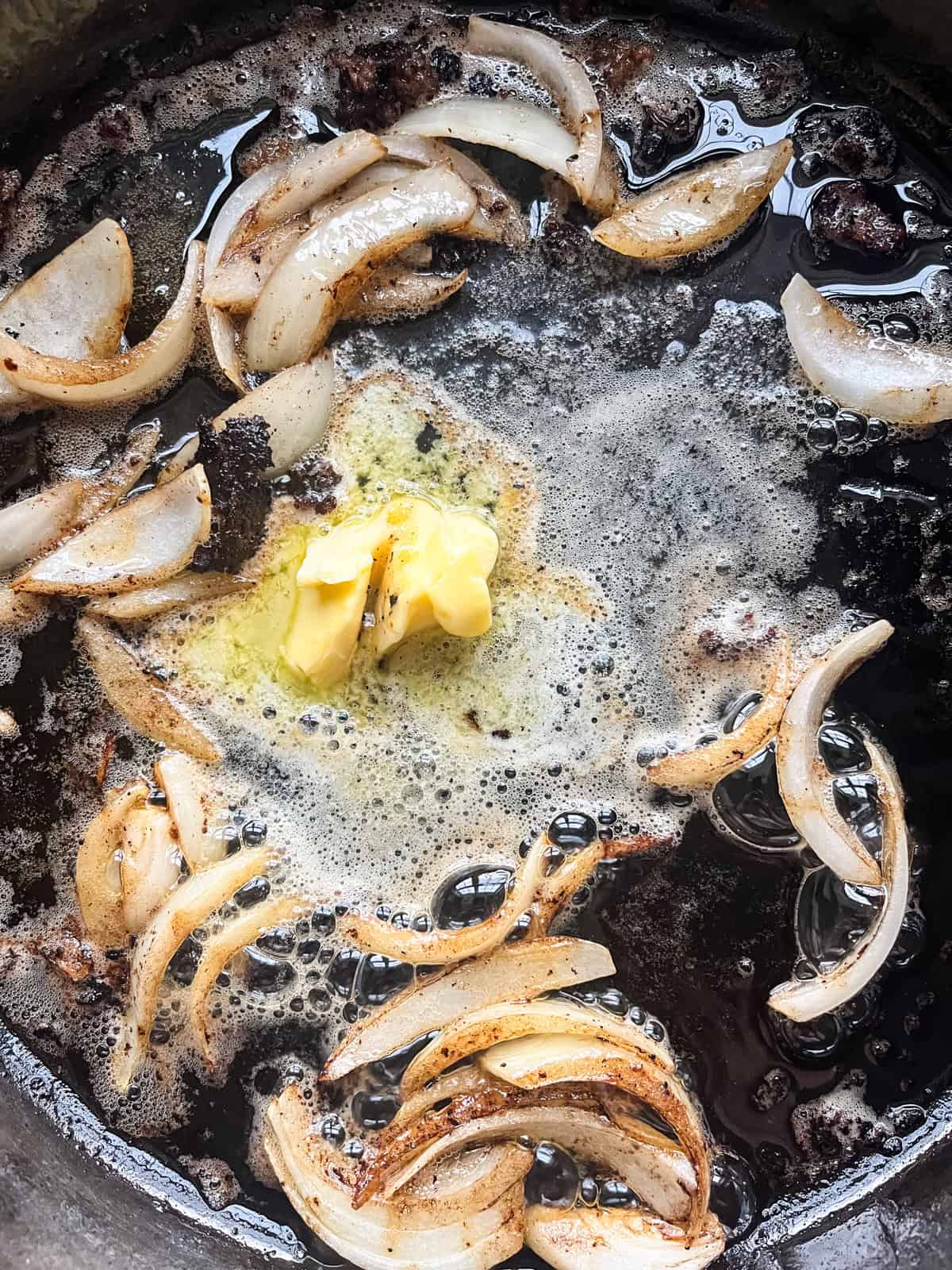 Cooking onions in melted butter in a cast iron skillet.