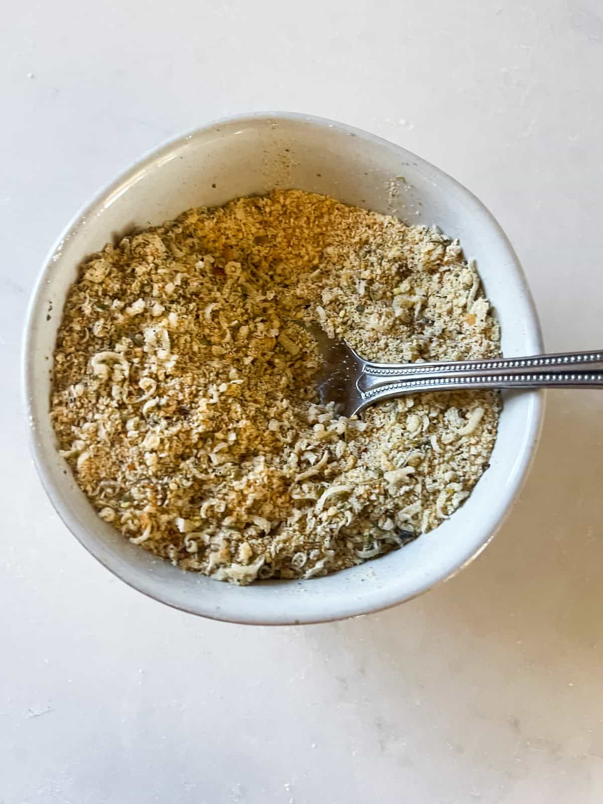 Mixing bread crumbs in a bowl.