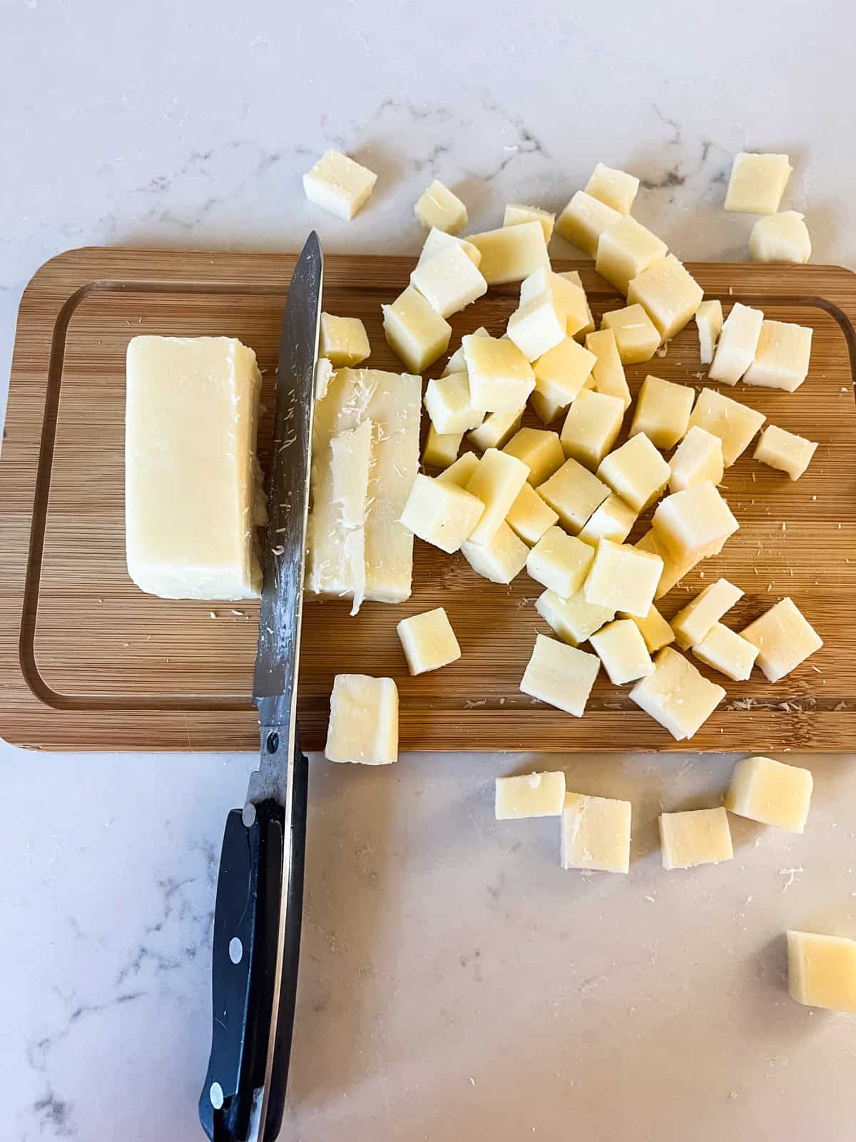 Cutting a block of cheese into small cubes.