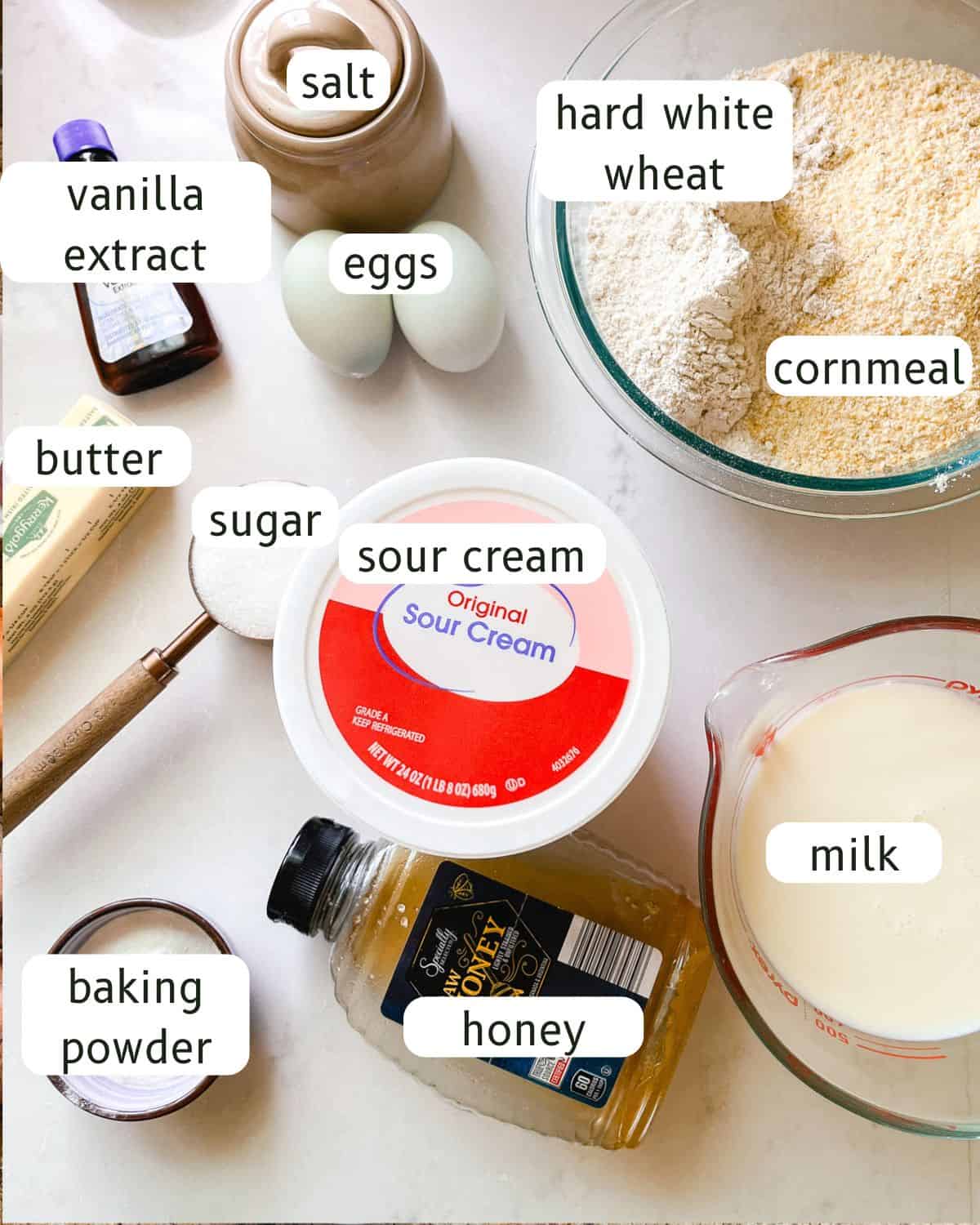 Whole wheat sweet corn muffins ingredients labeled on a kitchen counter.