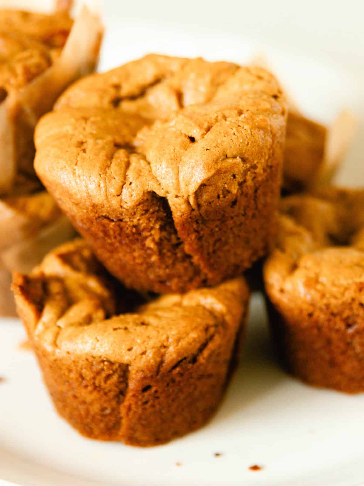 Grain-free peanut butter muffins stacked on a plate.