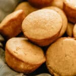 A basket of sweet corn muffins lined with a blue linen.