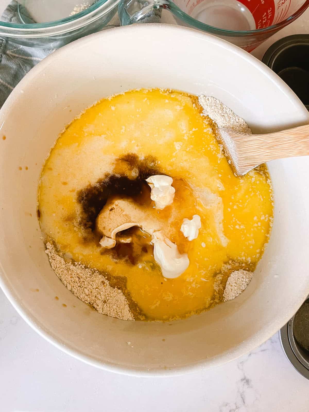 Mixing wet ingredients and dry ingredients with a wooden spoon.
