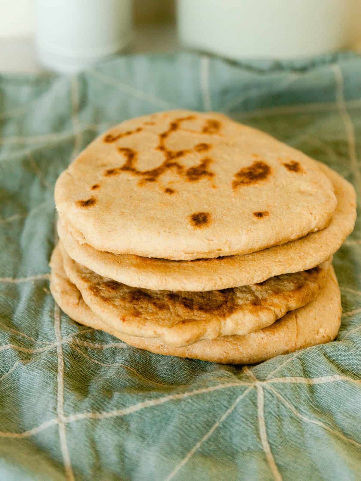 A stack of freshly milled flatbread on a blue towel.