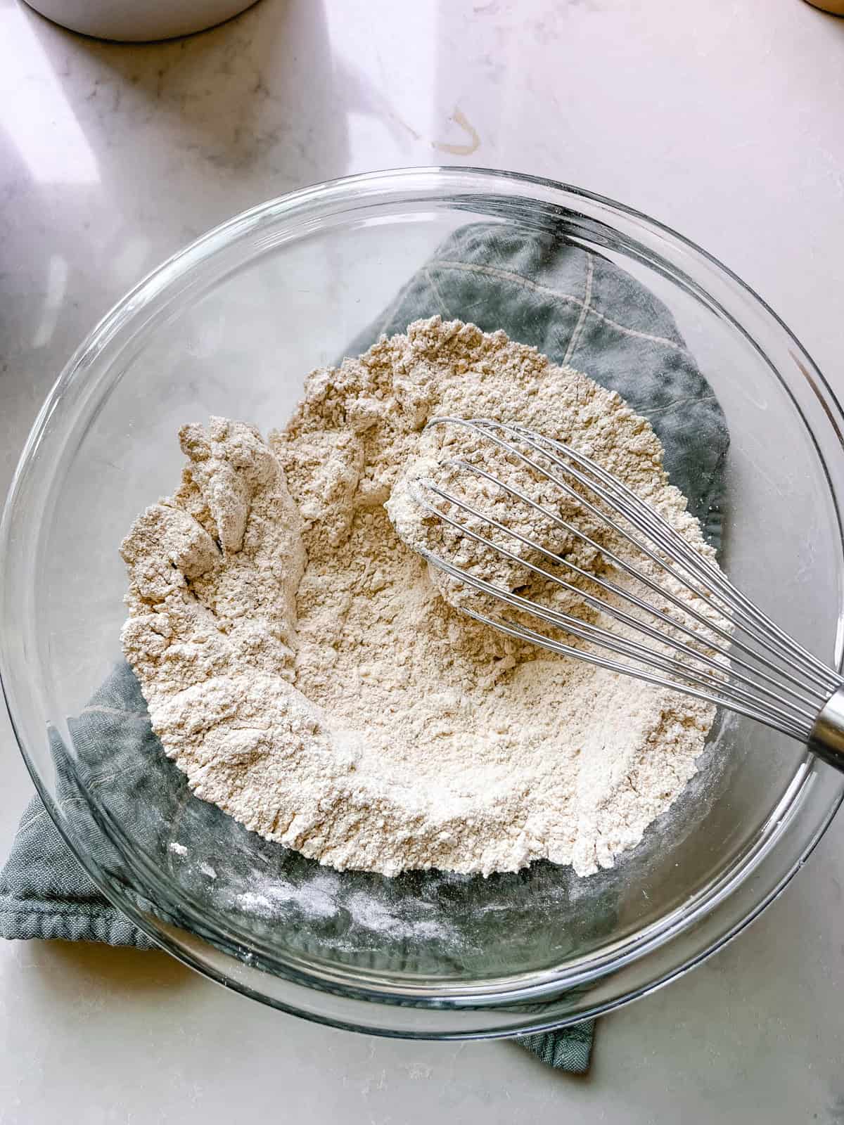 Stirring dry ingredients with a whisk.